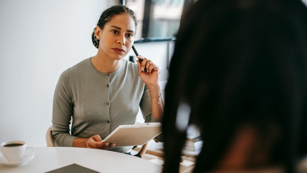 Female psychologist listens to man speak.