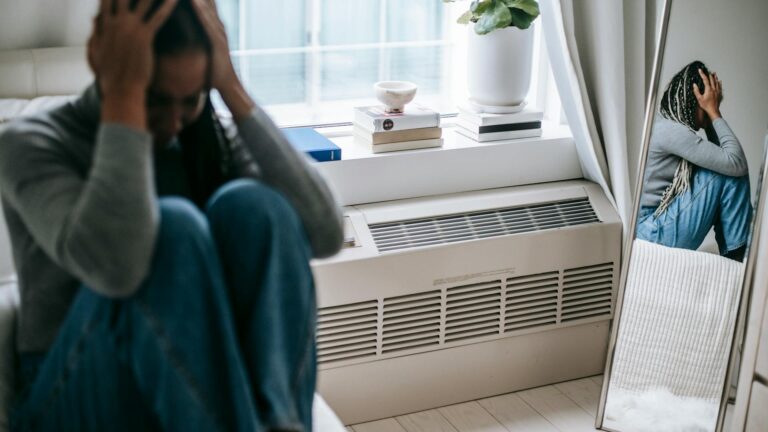 Reflection of distraught woman on her bed.