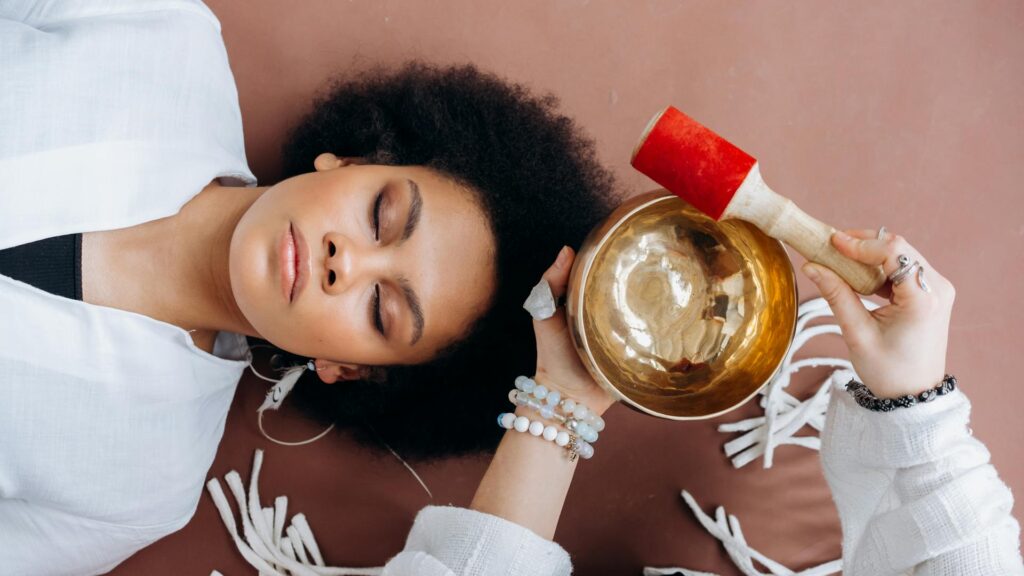 Woman using sound bowls in a therapy session.