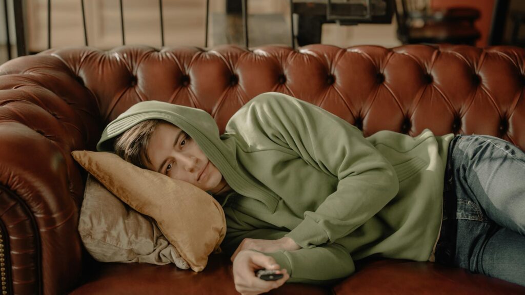 Man lying on couch with a remote.