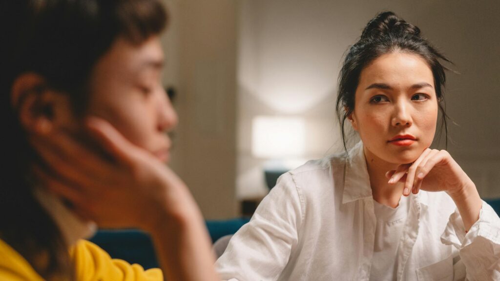 Woman looks uninterested at another woman.