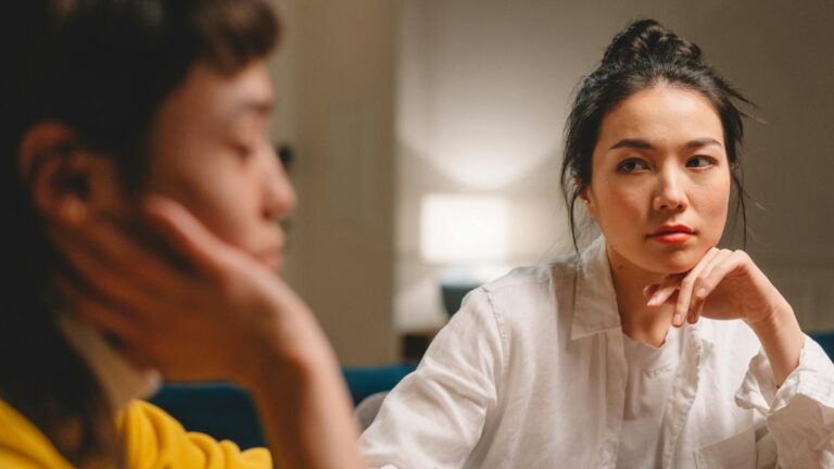 Woman looks uninterested at another woman.