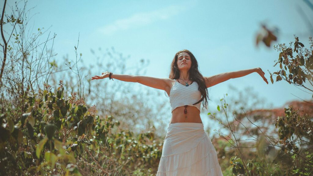 Woman stands with her arms open.
