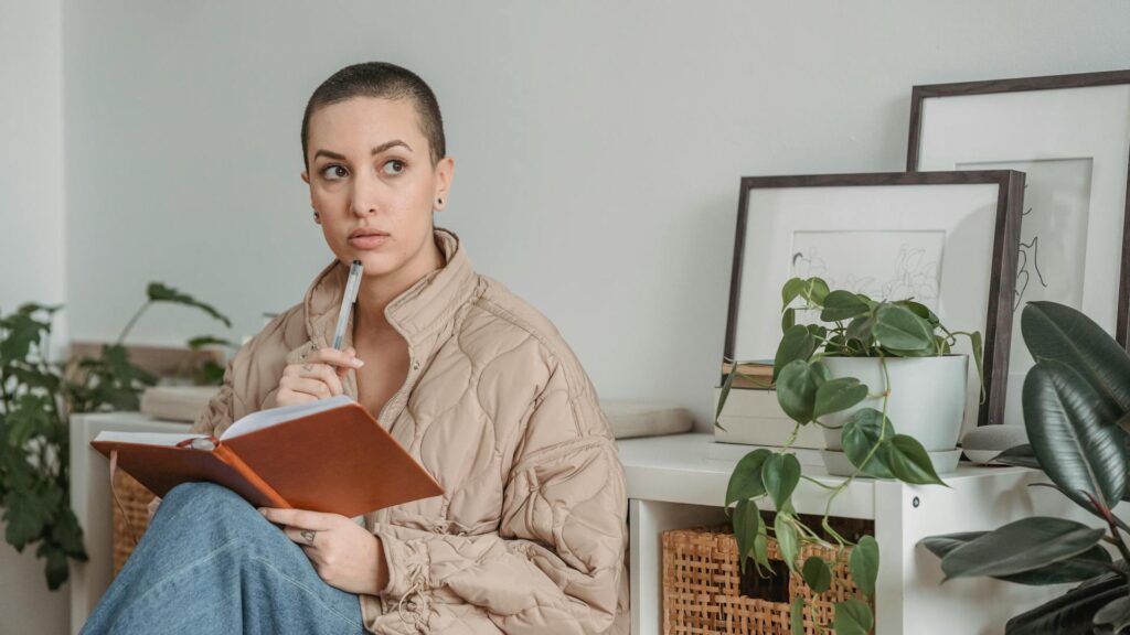Woman reflects while journaling.