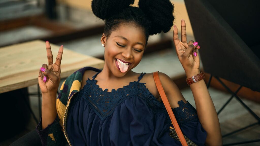 Girl throwing up peace signs and sticking out her tongue