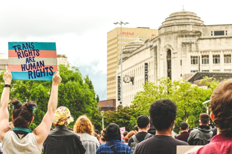 A woman holds up a sign during a protest that reads "Trans rights are human rights"