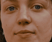 Close-up of a person with blue eyes, light skin, and neutral expression. The focus is on the face, capturing a calm and introspective mood.